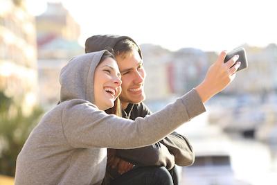 young couple taking a selfie with bright smiles