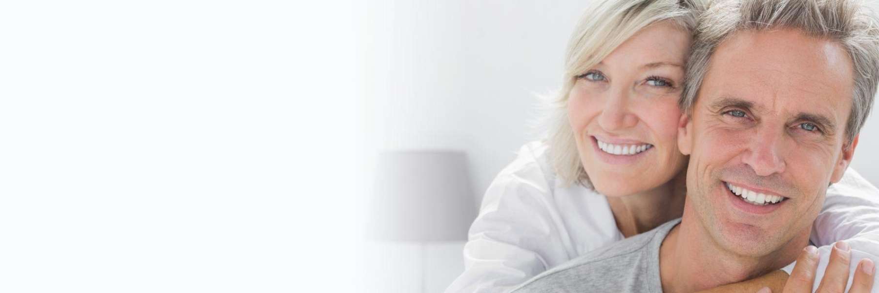 Happy middle-aged couple with healthy smiles after dental implants and bone grafting treatment in Ha