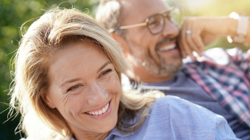 Smiling middle-aged couple outdoors, illustrating that adults can benefit from orthodontic treatment