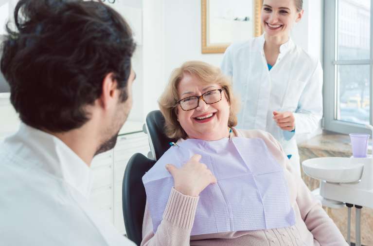 Older woman smiling during a dental consultation in Hampton Park for bruxism and TMJ treatment optio